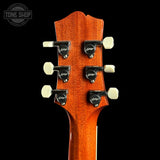 Guitar headstock with tuning pegs on a black background, featuring the Tone Shop logo.