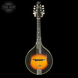 A mandolin with a classic sunburst finish, featuring a black outer edge, bright orange center, and gold-toned hardware, shown against a solid black background with a Tone Shop logo in the top left corner.
