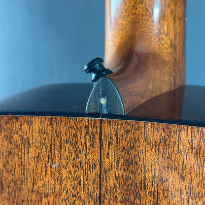 Close-up of a wooden object with a metallic component on a blue background