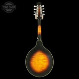 A mandolin shown from the back against a solid black background, featuring a dark brown to black flame finish with a vibrant orange and yellow figured wood burst in the center. The headstock is light-colored wood with silver tuning keys.