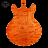 Close-up of a guitar body with a visible 'Tone Shop' logo.