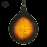 Close-up of the back of a mandolin with a glossy sunburst finish showing a vibrant orange and yellow maple wood grain against a black background.