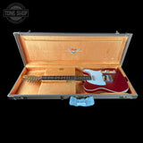 Red electric guitar in an open Fender case with 'Tone Shop' logo.