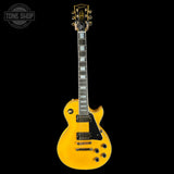Yellow electric guitar on a black background with 'Tone Shop' logo.