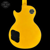 Yellow electric guitar with a visible brand logo on a black background