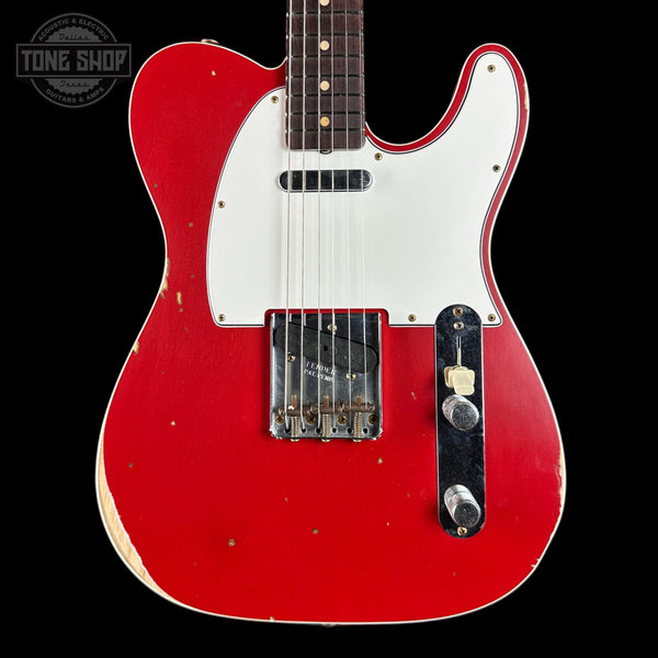 Red electric guitar with white pickguard on a black background, featuring 'Tone Shop' logo.