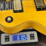 Yellow electric guitar on a digital scale displaying weight