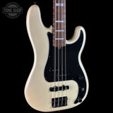 A cream-colored electric bass guitar with a black pickguard and black hardware, shown against a solid black background. A Tone Shop logo is visible in the top-left corner.