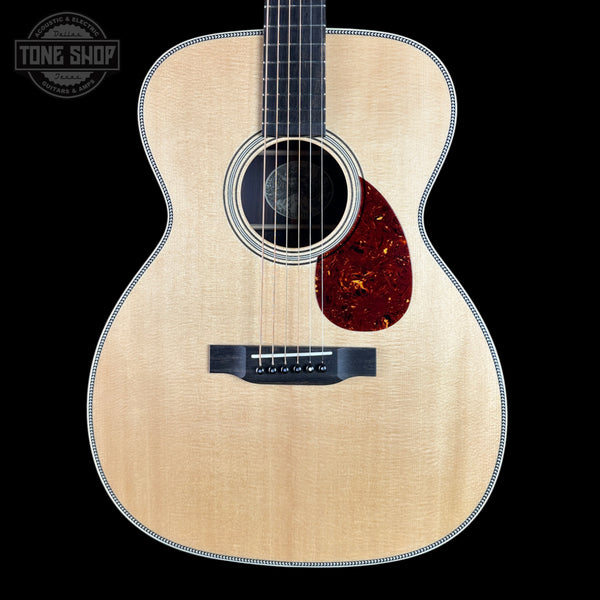 Acoustic guitar with a visible brand logo on a black background