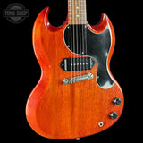 A classic electric guitar with a vibrant orange-red cherry wood finish, black pickguard, and chrome hardware, shown against a solid black background with a Tone Shop watermark in the top left corner.