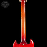 Close-up of the back of a glossy red electric guitar, showing the neck and body against a black background, with a Tone Shop watermark in the upper left.