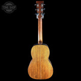 The back view of a wooden acoustic guitar against a solid black background, featuring a warm honey-toned wood finish and a 'TONE SHOP' watermark in the top-left corner.