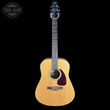 Acoustic guitar with a visible brand logo on a black background