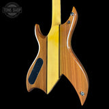 The back of an electric guitar made of two distinct wood finishes: a natural medium-brown wood body and a bright yellow maple neck, shown against a solid black background. A Tone Shop watermark is visible in the top-left corner.