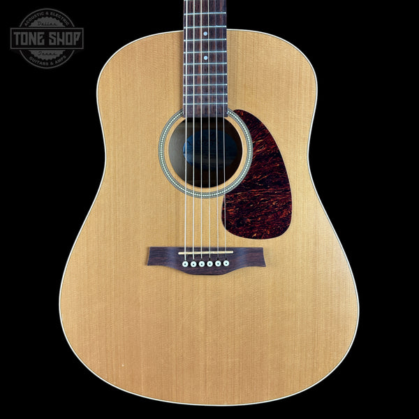 Acoustic guitar with a visible brand logo on a black background