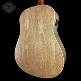 Back view of a wooden acoustic guitar with 'Tone Shop' logo in the corner.
