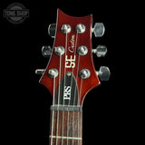 Guitar headstock with 'PRS Custom' branding on a black background