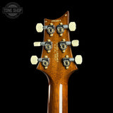 Close-up of a guitar headstock with 'Tone Shop' branding on a black background