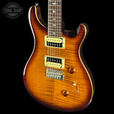 Electric guitar with a sunburst finish on a black background, featuring the Tone Shop logo.