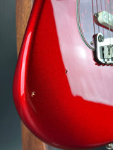 Close-up of a red electric guitar with a blurred background