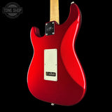 Red electric guitar with a visible brand logo on a black background