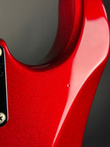 Close-up of a red guitar body with a blurred background