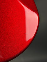 Close-up of a red ceramic plate with a glossy finish on a dark background