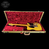 Yellow electric guitar in an open red-lined case with 'Tone Shop' branding.