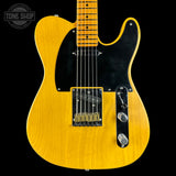 Yellow electric guitar with a black pickguard on a black background, featuring 'Tone Shop' branding.