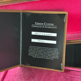 Gibson Custom Certificate of Authenticity inside a wooden case with pink interior.