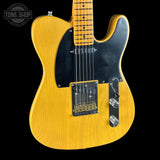 Yellow electric guitar with black pickguard on a black background, featuring 'Tone Shop' logo.