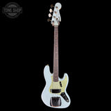 A Fender Stratocaster electric bass guitar in a light blue finish, featuring a dark brown maple fretboard and gold hardware, shown against a solid black background with a Tone Shop watermark in the top-left corner.