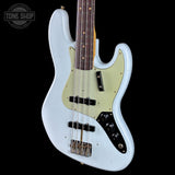A light blue electric bass guitar with a cream-colored pickguard, black hardware, and a dark brown fretboard, shown against a solid black background. A 'TONE SHOP' watermark is visible in the top-left corner.