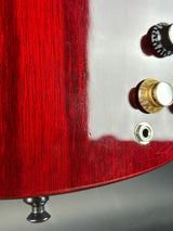 Close-up of a red guitar body with control knobs