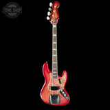 A Fender Jazz bass guitar with an ornate gold and pink filigree pattern on the body, shown against a solid black background. A Tone Shop watermark is visible in the top-left corner.
