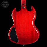 Red electric guitar body on a black background with 'Tone Shop' logo.