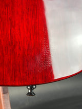 Close-up of a red guitar headstock with a white background