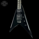 Black electric guitar with a unique shape on a black background, featuring 'Tone Shop' branding.