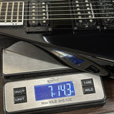 Black electric guitar on a digital scale displaying weight