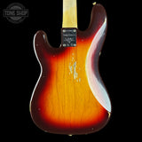 The back of a vintage-style electric guitar with a classic sunburst finish, showing a faded amber-orange center and dark brown edges, photographed against a solid black background.