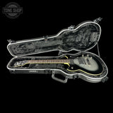 Guitar case with a guitar inside on a black background, featuring the Tone Shop logo.
