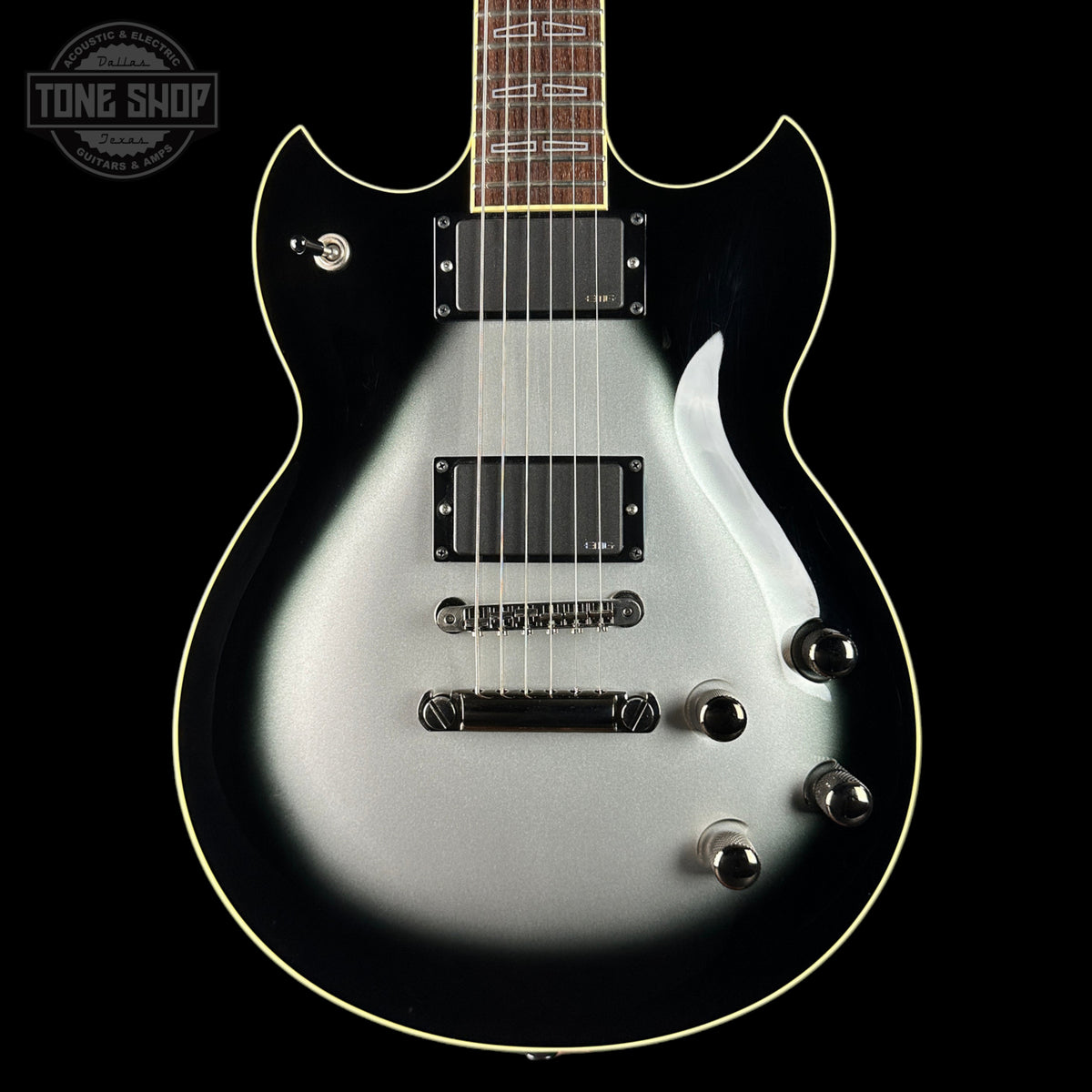 Silver electric guitar on a black background with 'Tone Shop' logo.
