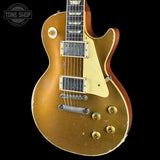 A classic electric guitar with a distressed gold finish, featuring a cream pickguard, gold-toned knobs, and a dark wood neck, shown against a solid black background with a Tone Shop watermark in the top left corner.