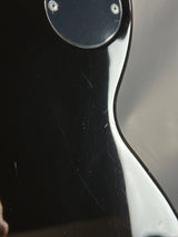 Close-up of a guitar's headstock with visible wear and tear.