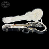 Guitar in a clear case with 'Tone Shop' logo in the corner