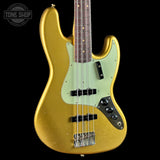 A gold-finished electric bass guitar with a mint green pickguard, black hardware, and a dark wood fretboard, shown against a black background with a Tone Shop watermark in the top left corner.