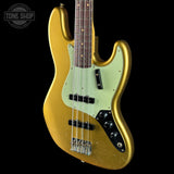 A gold-finished electric bass guitar with a mint green pickguard and black hardware, shown against a solid black background. A Tone Shop watermark is visible in the top left corner.