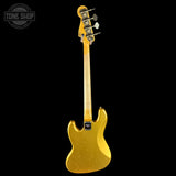 A gold-finish electric bass guitar shown from the back, featuring a maple neck and tailpiece, photographed against a solid black background with a Tone Shop watermark in the top-left corner.