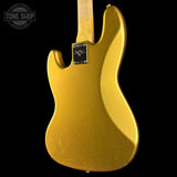 The back of a gold-finished electric guitar body, featuring a black 'Grimmer' brand badge, set against a solid black background with a Tone Shop watermark in the upper left.