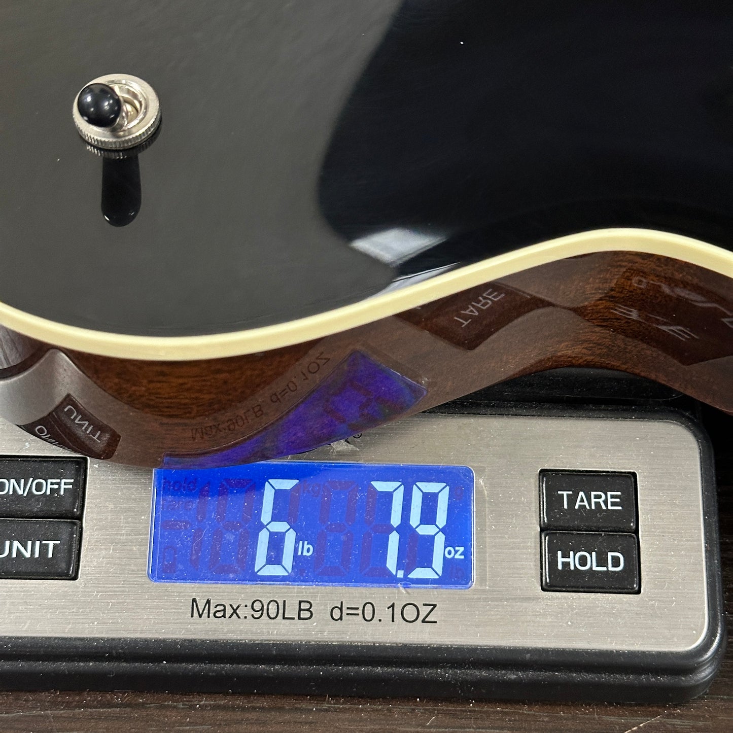 Collings 470-JL Antiqued Black on scale displaying weight.